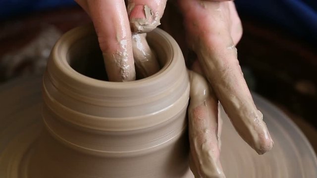 Process of creating a jar or vase of clay. Woman hands on potter's wheel