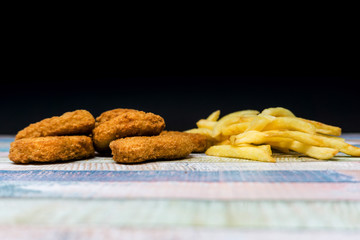 Chicken nuggets with sauce and golden French fries potatoes