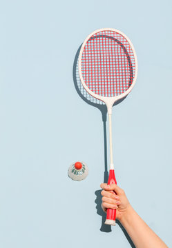 Woman's hand holding a retro badminton racket