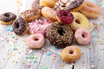 assorted donuts with chocolate frosted, pink glazed and sprinkles donuts.