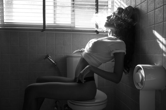 Asian sexy woman smoking with relax emotion at bathroom. People lifestyle concept. Black and white tone.