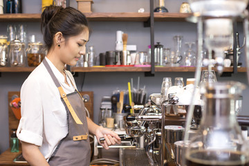 Asian Barista woman making Coffee with coffee machine in the coffee shop. people with barista in cafe concept.