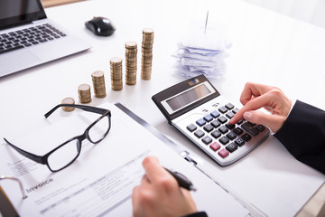 Businesswoman Calculating Invoice