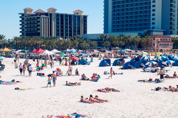 Strandurlaubszielszene, überfüllter tropischer Sandstrand von Clearwater Beach Florida, Leute, die sich sonnen, entspannen und Spaß am Strand haben, Ferienhotelanlagen im Hintergrund