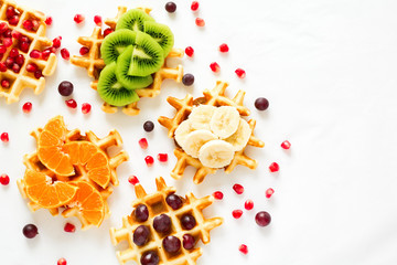 Top view on Belgian waffles with fruit topping. Flat lay. Space for copy