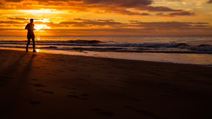 Fototapeta na wymiar Man is running by the beach at sunrise.