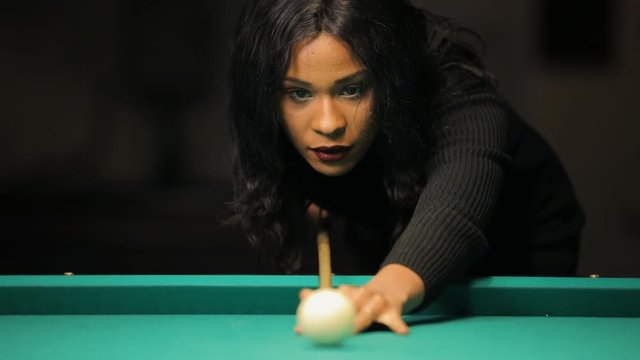 Billiards, concentrated young woman playing in club