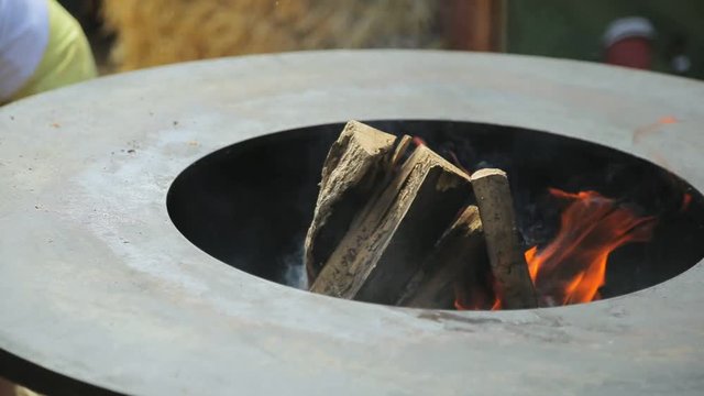 Empty large round barbecue for frying with firewood in the middle