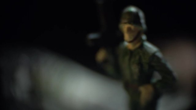 A toy soldier in green uniform holds an automaton