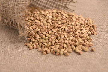 Scattered buckwheat grains. Healthy food. Brown background