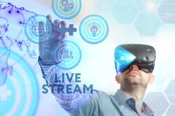 Business, Technology, Internet and network concept. Young businessman working in virtual reality glasses sees the inscription: Live stream