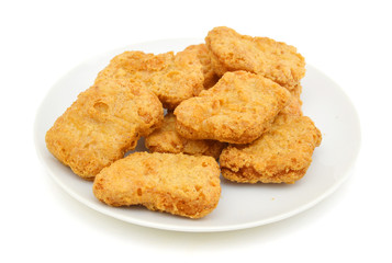 Macro of fried chicken nuggets in white plate on white background