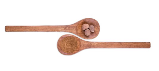 Nutmeg powder and whole nutmeg on wooden spoons isolated on white background