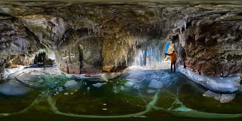 Panorama man in an ice cave with icicles on Baikal, Olkhon, Spherical 360 vr degree panorama