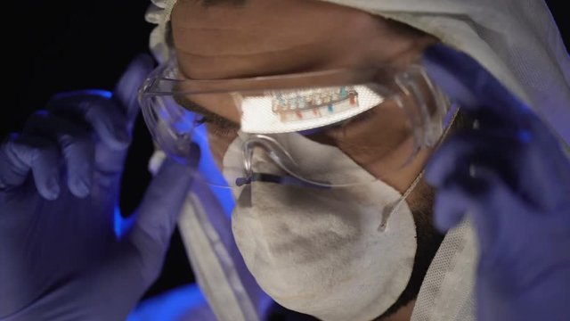 Assistant wearing glasses, reflection of test tubes with chemical substance