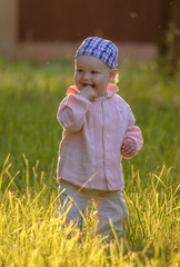 little boy on a green lawn in summer