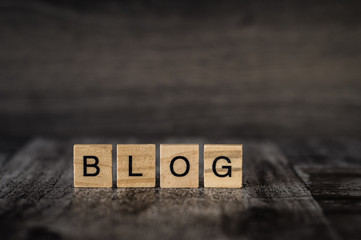 the word blog made of bright wood cubes with black letters on a dark wooden background