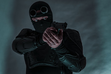 Armed spy in bulletproof vest. The gun is aimed at the target.