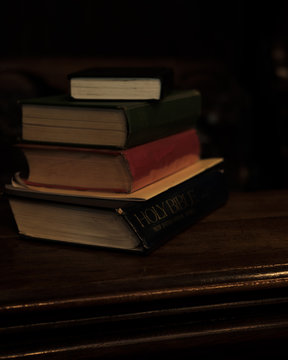 Close up of a stack of worn bibles in a church