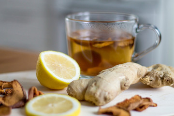 Home made hot dried apple drink with lemons and ginger, kitchen interior