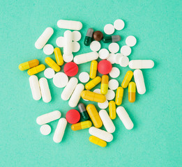 handful of scattered medicines, pills and tablets on blue background