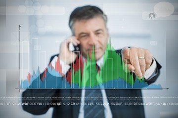 Businessman selecting point on large graph on touchscreen