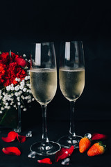 Concept picture for Valentine's day. 2 glasses of Champaign with rose petal, strawbery and flower