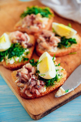 bruschetta, appetizer, canapes: fish and spinach on toast of white bread, with egg
