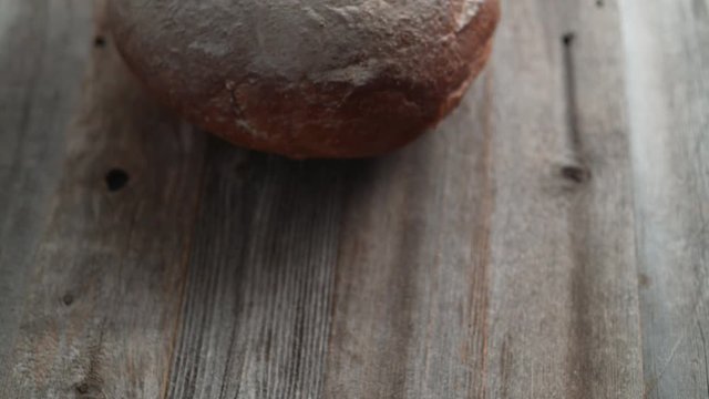 A whole sourdough bread falling on a table. Shot with high speed camera, phantom flex 4K. Slow Motion.