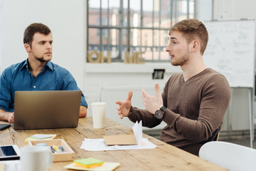 Two young businessmen in an animated discussion