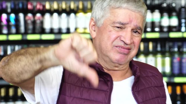 Man Thumbs Down - Dissatisfied with Bottles on background