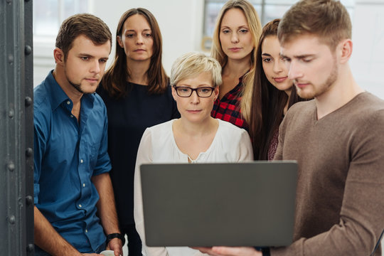 Group of people in front of laptop at office