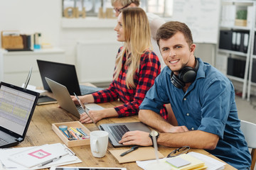 Fototapeta premium Young man with headphones working in a business team