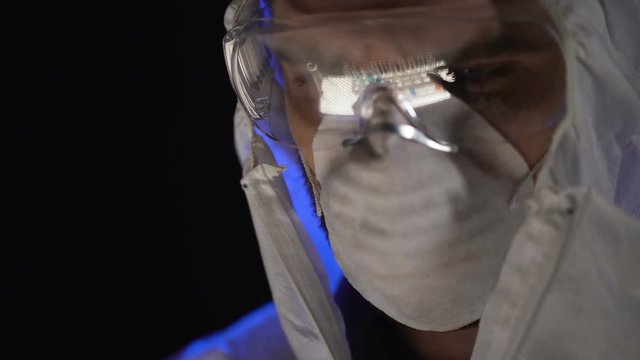 Test tubes reflected in safety glasses, scientist mixing substances, close up