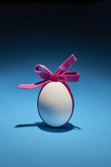 Uova con fiocchi colorati a ricorrenza della Pasqua su fondo azzurro