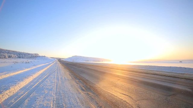 Winter road through snowy fields and forests