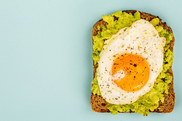 Fried Egg Sunny Side Up on Crushed Avocado And Rye Bread Open Faced Sandwich