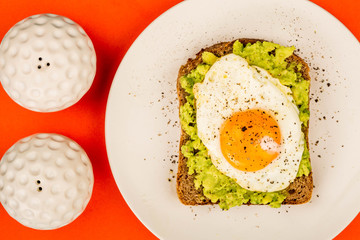 Fried Egg Sunny Side Up on Crushed Avocado And Rye Bread Open Faced Sandwich