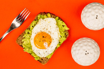 Fried Egg Sunny Side Up on Crushed Avocado And Rye Bread Open Faced Sandwich