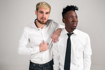 Two stylish men posing and having fun on white background.