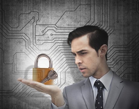 Concentrated businessman holding a padlock 