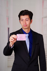 Sad business man holding a paper of you're fired text on it, in a blurred background
