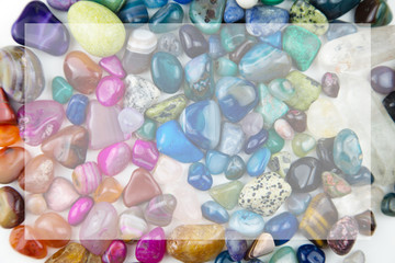 various tumbled bright coloured semi precious gemstones with copy space