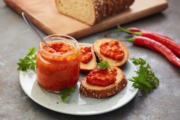 Ajvar (pepper mousse) in a jar and on a slices of bread