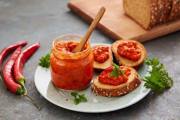 Ajvar (pepper mousse) in a jar and on a slices of bread