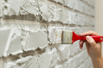 ladies hand painted brick brush white wall.