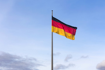 big german flag in front of a blue sky