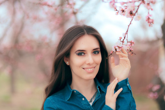 Beautiful Smiling Woman Near Pink Blooming Spring Tree