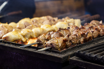 The process of cooking shish kebab on a metal grill in the open air.Grilling shashlik on barbecue grill. Marinated meat.