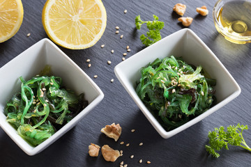 Fresh seaweed salad in two square bowls on a dark background © Madeleine Steinbach